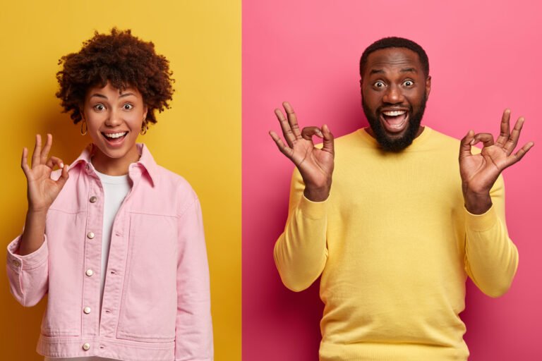 Positive dark skinned smiling woman and man show okay gestures with satisfied assertive expressions, promote item or recommnend buyig product, give excellent feedback, rate something awesome