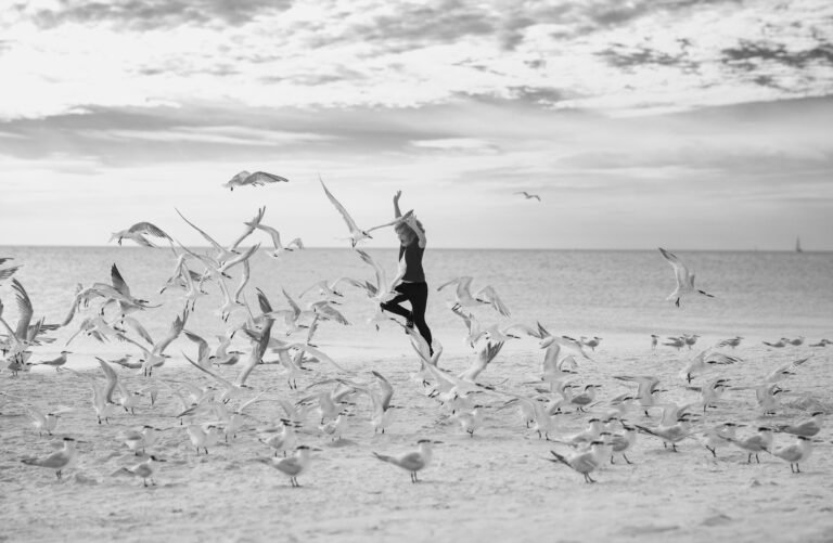 Happy childhood. Child run on the seagulls on the beach, summer time. Cute little boy chasing birds near sea on summer day.